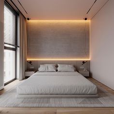 a large white bed sitting in a bedroom next to a wall mounted light above it