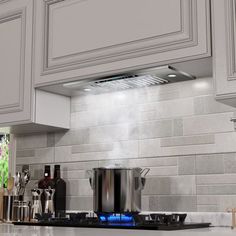 a stove top oven sitting inside of a kitchen next to white cabinets and counter tops