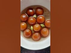 a white bowl filled with oranges on top of a table