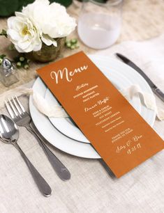 a table setting with silverware and menu cards