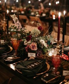 the table is set with candles, plates and place settings for an elegant dinner party