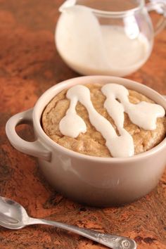 a bowl of food on a table next to a pitcher of milk and a spoon