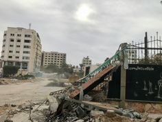 an abandoned building with graffiti on it and stairs leading up to the top floor in front of some buildings