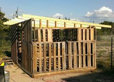 a building made out of wooden pallets in the dirt