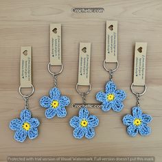 four crocheted key chains with flowers attached to them