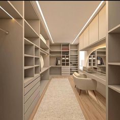 a large walk in closet with lots of shelves and drawers on the wall, along with a white chair