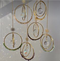 several circular pendants hanging from chains with crystals and sunbursts on them