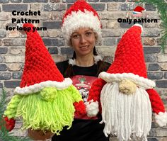 two crocheted santa hats with green and red yarn on them, one is holding an object