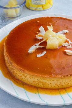 there is a cake on the plate with caramel sauce and coconut flakes around it