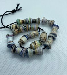 three bracelets made out of glass beads on a white surface with a black string