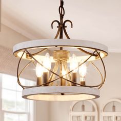 a chandelier hanging from the ceiling in a room with white walls and windows