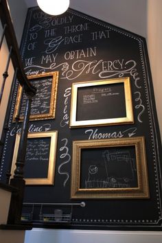 a blackboard with writing on it and gold framed pictures hanging up against the wall