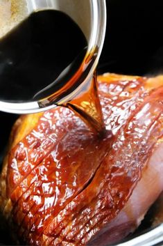 someone is pouring sauce on a piece of meat in the slow cooker to cook it