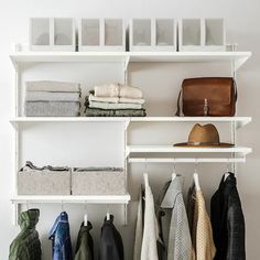 a white shelf filled with lots of clothes next to a wall mounted coat dryer