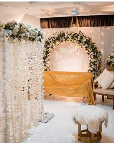 a decorated stage with white flowers and greenery