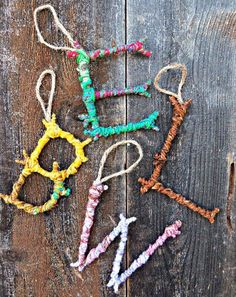 four different colored beads hanging from strings on a wooden surface with the word love spelled in small letters