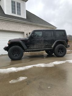 a black jeep parked in front of a house