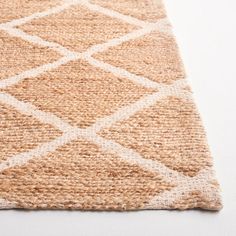 a beige rug with white squares on the top and bottom, is shown in close up