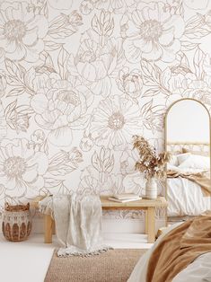 a bedroom with floral wallpaper and a mirror on the side table in front of it