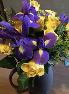 a blue vase filled with purple and yellow flowers