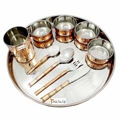 there is a tray with cups and spoons on it, along with silverware