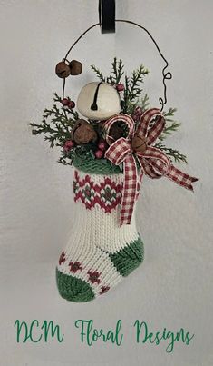 an ornament hanging from the side of a christmas stocking decorated with pine cones and berries