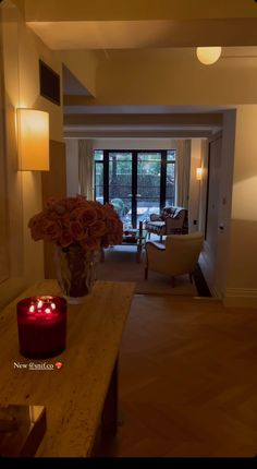 a living room filled with furniture and a red candle on top of a wooden table