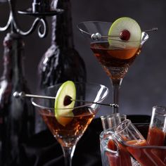 two glasses filled with different types of cocktails and garnished with cherries