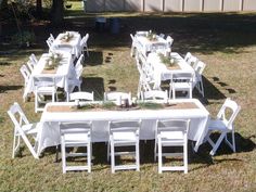 there are many tables and chairs set up in the yard for an outdoor dinner party