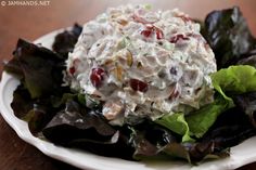 a white plate topped with salad on top of a wooden table