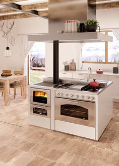 a stove top oven sitting inside of a kitchen next to a dining room table and chairs