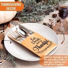 a thanksgiving place setting with silverware and napkins on a white plate surrounded by pine branches