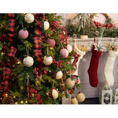 christmas stockings hanging from a fireplace mantel in front of a decorated christmas tree with red, white and green stocking