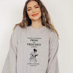 a woman wearing a grey sweatshirt with the words pride and prejuce on it