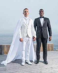 two men in tuxedos standing on a pier