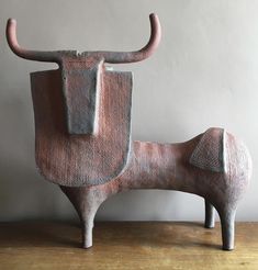 an animal shaped sculpture sitting on top of a wooden table