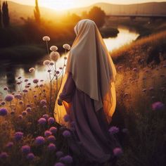 a woman wearing a veil standing in a field with dandelions and flowers at sunset