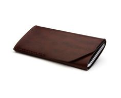 a brown leather wallet sitting on top of a white surface