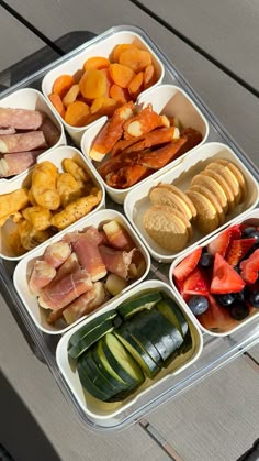 a plastic container filled with lots of different types of food on top of a wooden table