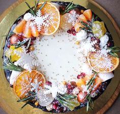 a cake with oranges, cranberries and powdered sugar on top