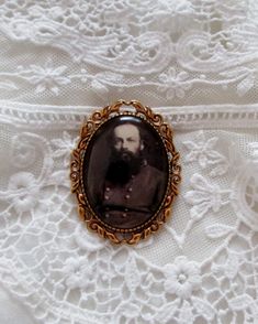 "With handsome clarity, and a rich antiqued setting, this cameo brooch measures 2.25 inches in length. The historical period photo reproduction is set under a high quality glass dome. Every item in our shop is handmade, and created with loving care.   Please note: The glare on the cameo occurs from the photo and is not a blemish on the piece. Our cameos are resistant but not waterproof and should not be submerged in water or worn when swimming or bathing. Your treasures come tucked into a lovely organza bag. If your order is being sent directly to a gift recipient, we are delighted to take part in your thoughtfulness, and are happy to include a card with your personal message. Simply include your message in the \"message to seller\" space when ordering. (no receipt will be included) Photo, Antique Wedding Lapel Pin, Bronze Victorian Brooches For Gifts, Victorian Bronze Brooches For Gift, Vintage Brooch With Antique Finish, Historical Period, Cameo Brooch, Glass Dome, Glass Domes, Organza Bags