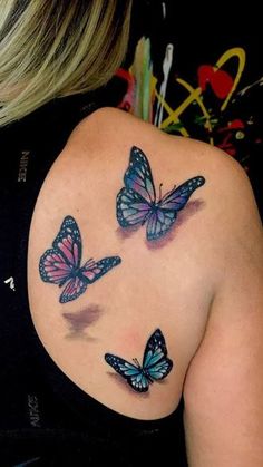 the back of a woman's shoulder with three butterflies on it