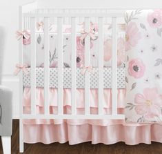 a white crib with pink flowers and polka dots