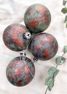 four red and green ornaments on a white cloth