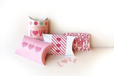 three decorative pillows with hearts on them and the word love spelled out in pink letters