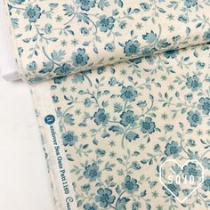 a blue and white flowered fabric with hearts on the bottom corner, next to a ruler