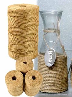 three rolls of twine next to two vases