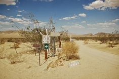 a dirt road in the middle of nowhere with signs on it that say no parking