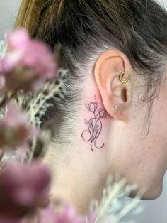 a woman with a small tattoo behind her ear