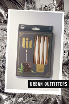 an unopened box with candles in it on top of tin foil and the words urban outfitters